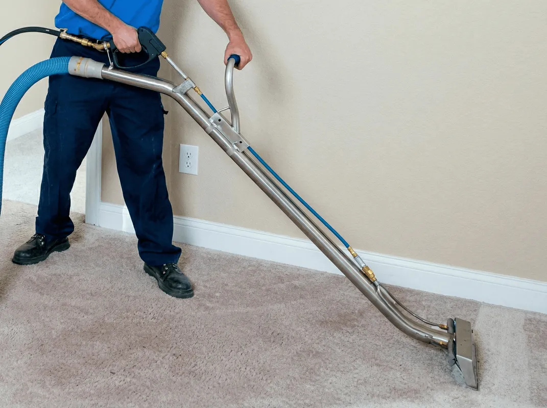 Professional operating a liquid removal machine on a carpeted floor in Manchester, NH